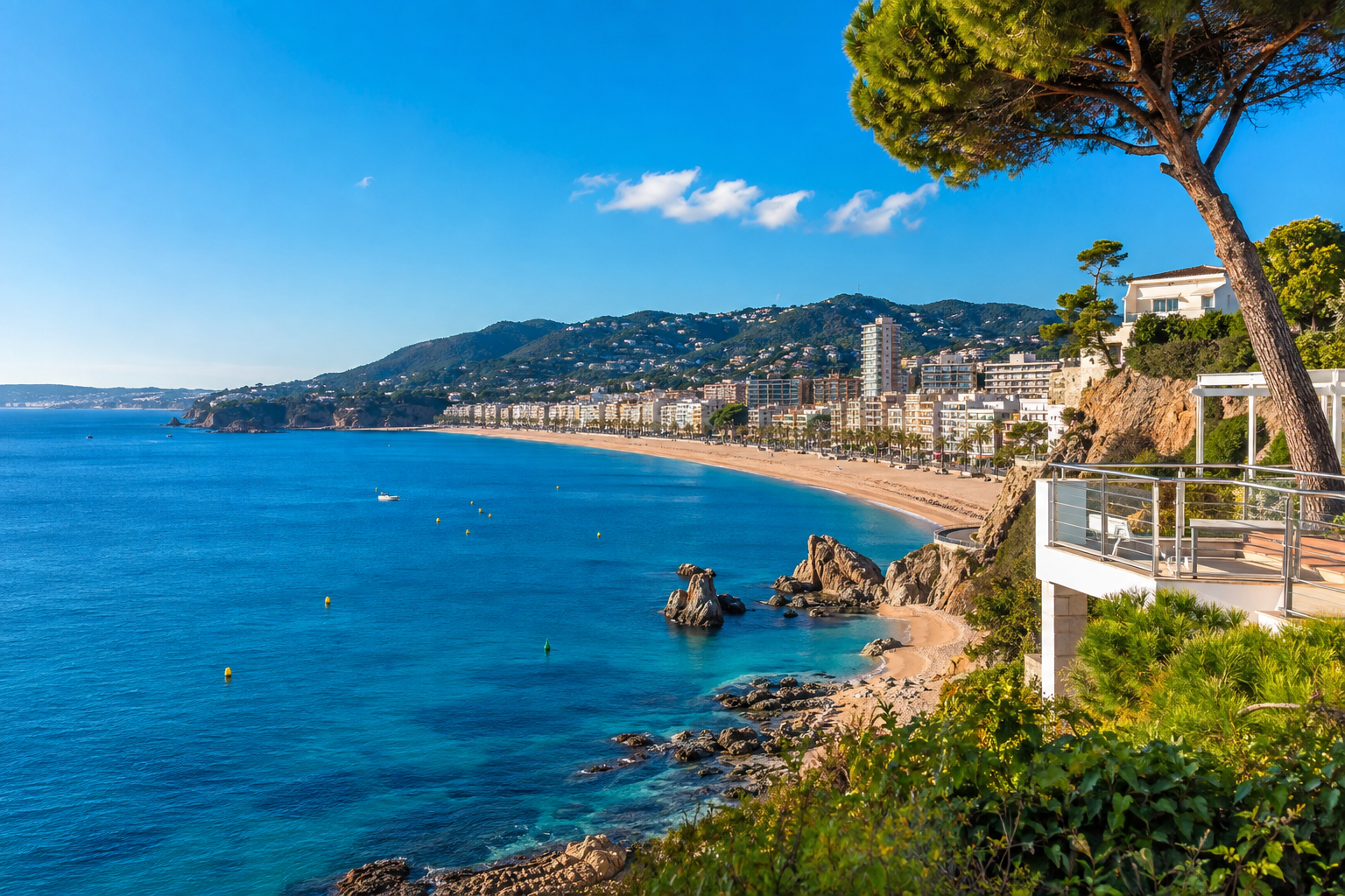 Vista mediterránea de Lloret de Mar con playa, edificios residenciales y viviendas en la ladera, representativa del mercado de compra y alquiler de pisos.